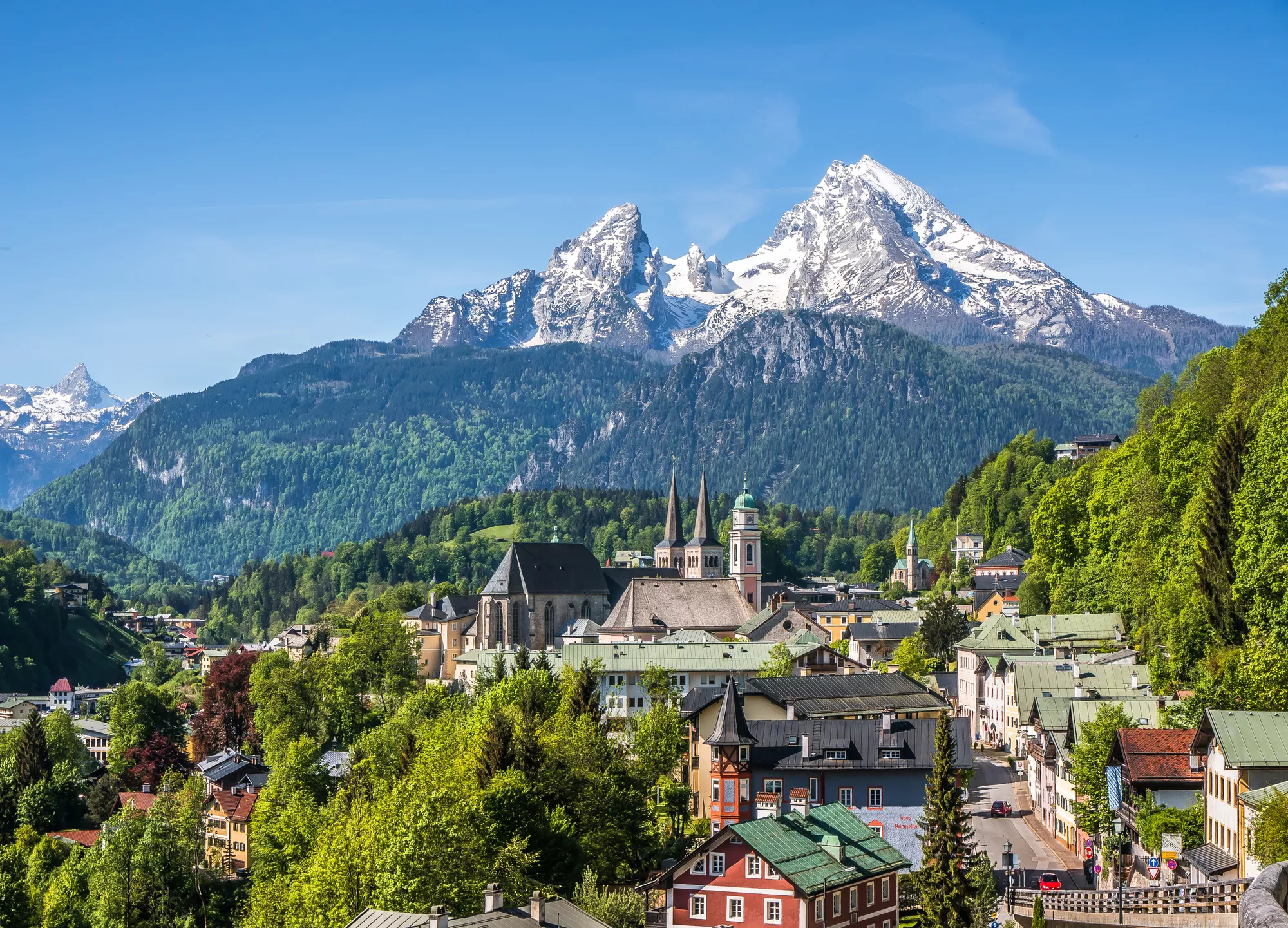 Bergdorp met kleurrijke huizen, sneeuwtoppen van de Alpen op de achtergrond