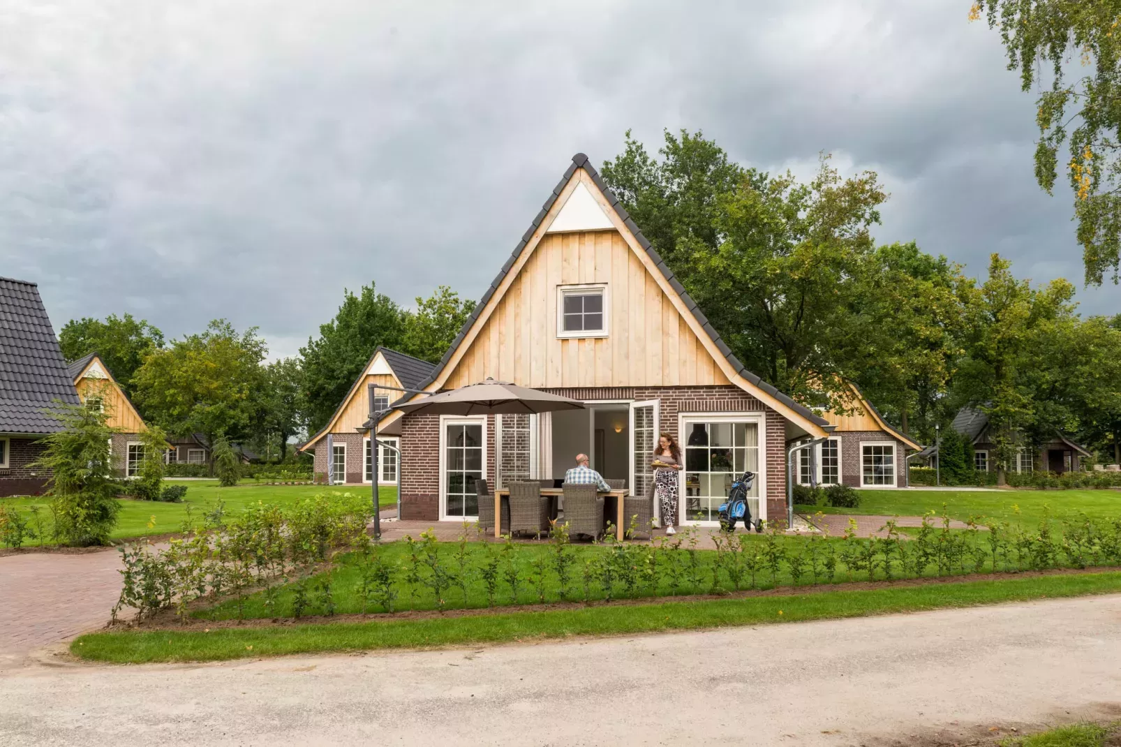 mensen die op tuinset voor vakantiehuisje zitten p grijze dag